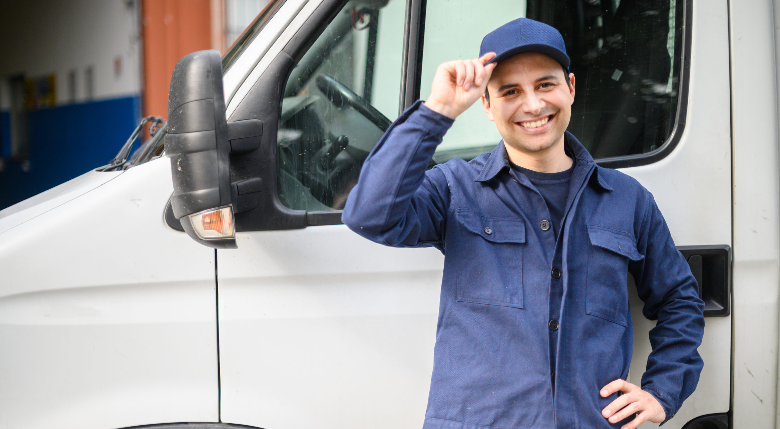 Portrait of a driver standing enar his van and smiling